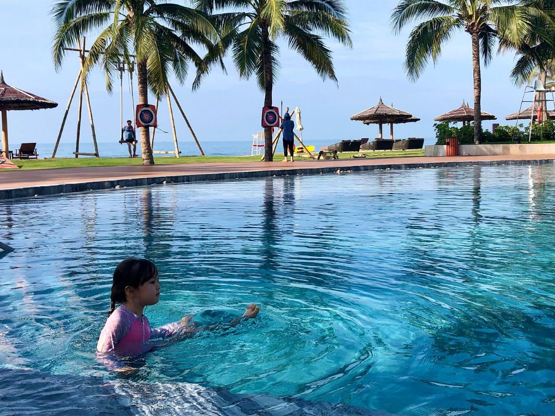 Hồ bơi tại Angsana Hồ Tràm nằm giữa vườn và biển, dài như con suối chảy ngang resort
